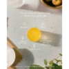 Center orange cup sits on a speckled countertop with Greek text about Fibre Concentrate benefits and small icons around it (Vitamin C, Fibre, vegan & gluten-free, natural sweetener).